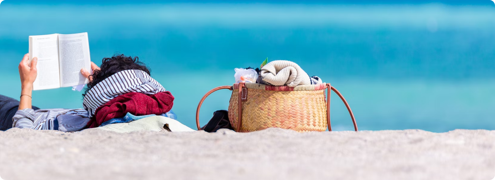 women reading a book at the beach